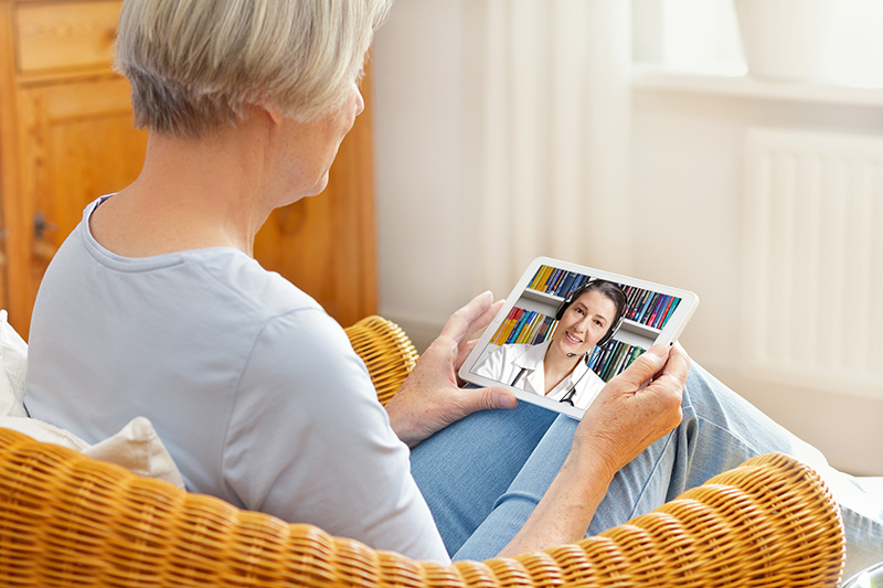 Senior woman using tablet computer for telehealth appointment