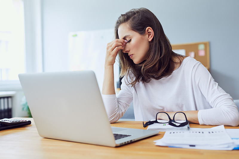 Woman stressed at work in front of a laptop